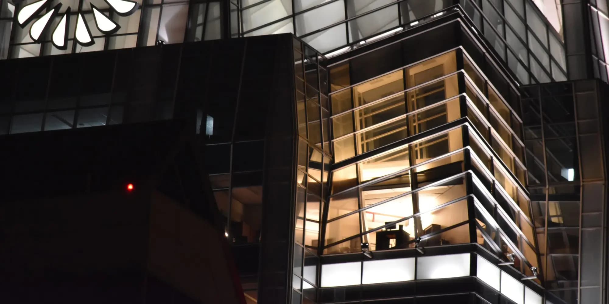 Glass corner office lit up at night