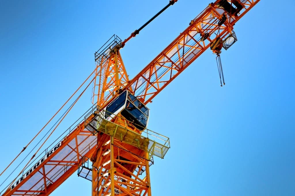 Orange tower crane against a blue sky